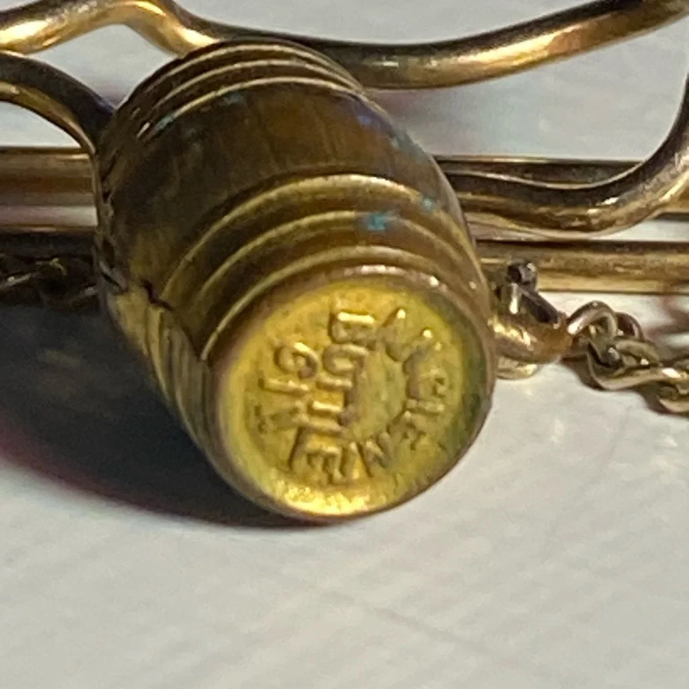 Early 1900’s brass tie cop/ money clip. Beer barrel pendant marked